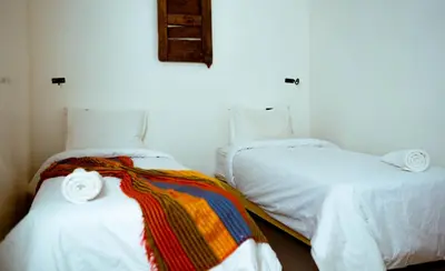 two beds sitting next to each other in a room at L'oasis Du Bonheur in Aït Ben Haddou