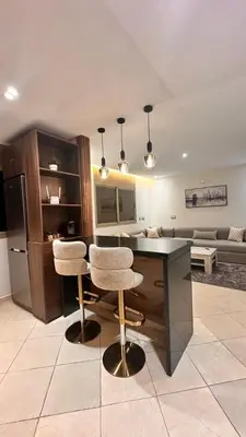 a kitchen with a table and two chairs and a couch at Modern Flat in Khouribga in Khouribga