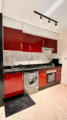 a kitchen with red cabinets and a washing machine at Modern Flat in Khouribga in Khouribga