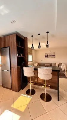a kitchen with a table with two chairs and a refrigerator at Modern Flat in Khouribga in Khouribga
