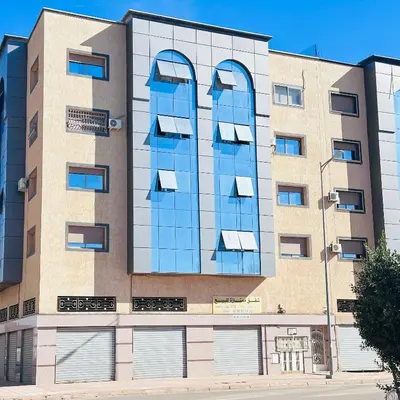 an external view of a building with blue glass at Modern Flat in Khouribga in Khouribga