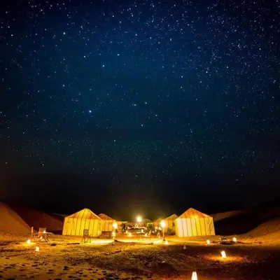 a group of huts in the desert at night at Under 1000 Stars Camp in Merzouga