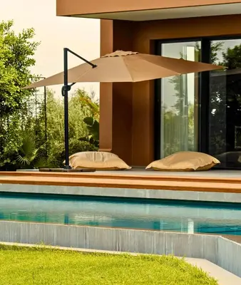 an umbrella sitting next to a swimming pool at Villa Timenkar - Moroccan spa and mountain panorama in Aghmat
