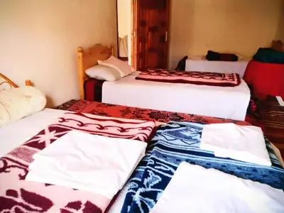 a group of three beds in a room at Riad hotel Étoile dades Camping in Aït Ali Ou Allah