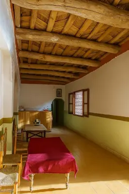a room with a red bed and a table at Riad hotel Étoile dades Camping in Aït Ali Ou Allah