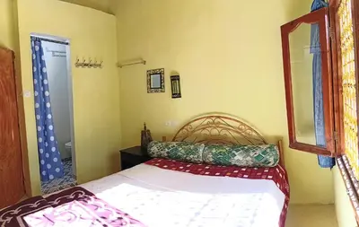 a small bedroom with a bed and a mirror at Riad hotel Étoile dades Camping in Aït Ali Ou Allah