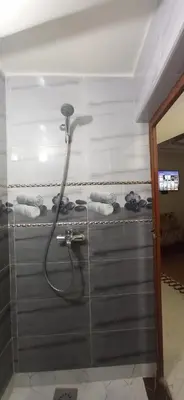 a shower with a shower head in a bathroom at شقة في موقع سياحي لمحبي المناظر الخلابة وشلالات in Beni Mellal
