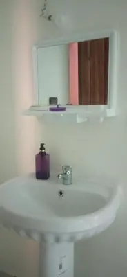 a bathroom sink with a mirror and a purple soap at شقة في موقع سياحي لمحبي المناظر الخلابة وشلالات in Beni Mellal