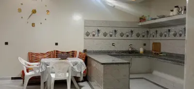 a kitchen with a table and chairs and a counter at شقة في موقع سياحي لمحبي المناظر الخلابة وشلالات in Beni Mellal