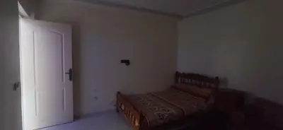 a bedroom with a bed in a room with a door at شقة في موقع سياحي لمحبي المناظر الخلابة وشلالات in Beni Mellal