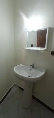 a bathroom with a white sink and a mirror at شقة في موقع سياحي لمحبي المناظر الخلابة وشلالات in Beni Mellal