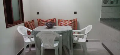 a table with white chairs and a vase on it at شقة في موقع سياحي لمحبي المناظر الخلابة وشلالات in Beni Mellal