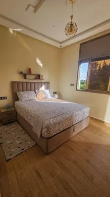 a bedroom with a large bed and a window at 2 bedroom apartment, low price & comfort in Oulad Akkou