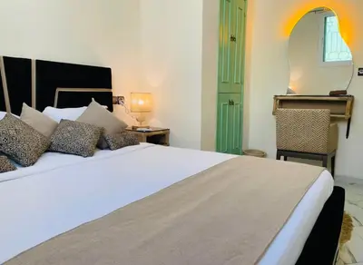 a bedroom with a large white bed and a green door at Traditional Apartment in Heart of Old Medina in Fès