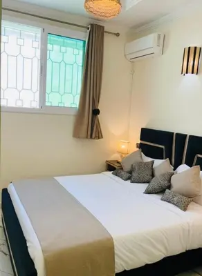 a bedroom with a large white bed with a window at Traditional Apartment in Heart of Old Medina in Fès