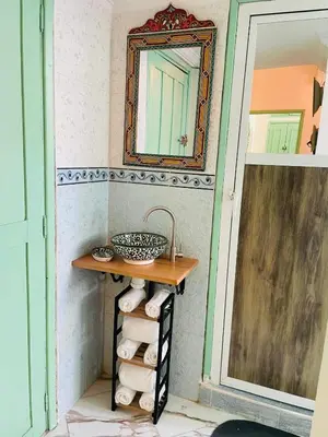 a bathroom with a mirror and a shelf with towels at Traditional Apartment in Heart of Old Medina in Fès