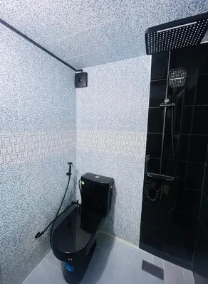 a bathroom with a black toilet and a shower at Traditional Apartment in Heart of Old Medina in Fès