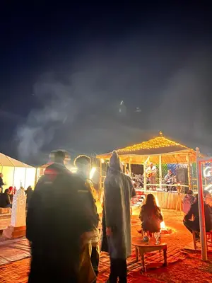 a group of people walking around a market at night at Sahara Whisper Luxury Camp in Merzouga