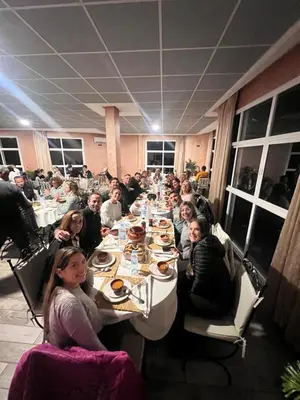 a group of people sitting at a long table at Sahara Whisper Luxury Camp in Merzouga
