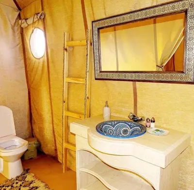 a bathroom with a sink and a mirror and a toilet at Sahara Whisper Luxury Camp in Merzouga