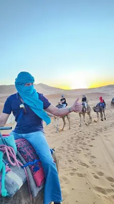 a group of people riding on camels in the desert at Sahara Whisper Luxury Camp in Merzouga