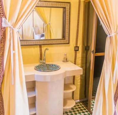 a bathroom with a sink and a mirror at Sahara Whisper Luxury Camp in Merzouga