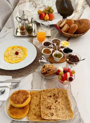 a table topped with plates of food and bowls of fruit at Villa B Marrakech Chambre d hôtes Guest House Adult Only piscine privée zéro vis à vis in Marrakech