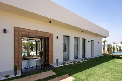 a large white building with a lawn in front of it at Villa B Marrakech Chambre d hôtes Guest House Adult Only piscine privée zéro vis à vis in Marrakech