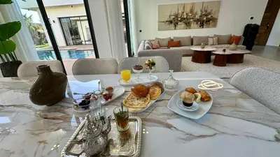 a table with plates of food on top of it at Villa B Marrakech Chambre d hôtes Guest House Adult Only piscine privée zéro vis à vis in Marrakech
