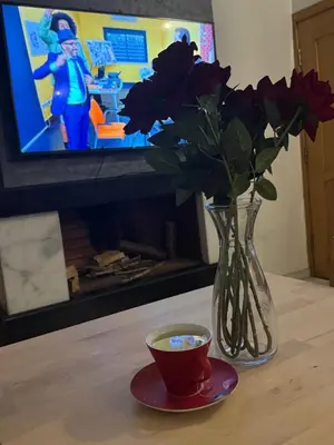 a vase with flowers and a cup of coffee on a table at Fleury in Fès
