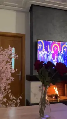 a vase of flowers sitting on a table with a television at Fleury in Fès
