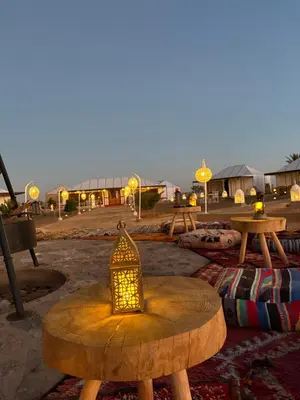 a table with a lantern sitting on top of it at Peaceful Luxury Camp in Merzouga