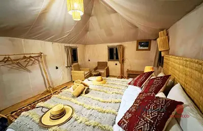 a large bed in a tent with hats on it at mhamid luxury camps in Mhamid El Ghizlane