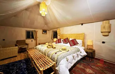a bedroom with a bed in a tent at mhamid luxury camps in Mhamid El Ghizlane