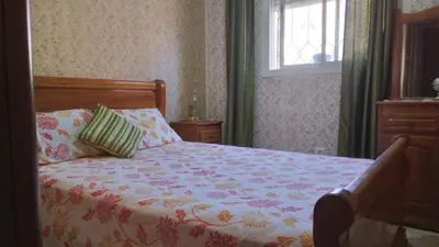 a bedroom with a bed and a window at Ravissante appartement dans les jardins in Oulad Akkou