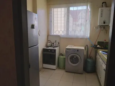 a kitchen with a stove and a washing machine at Ravissante appartement dans les jardins in Oulad Akkou