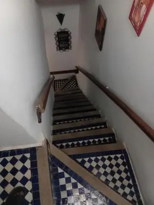 a staircase with a checkered floor in a room at Riadnomadfes in Fès