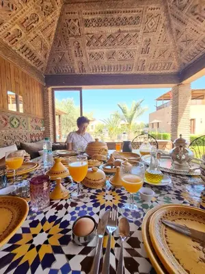 a table with plates and glasses of orange juice on it at Riadnomadfes in Fès