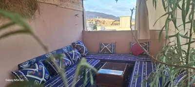 a balcony with a couch with pillows and a window at Riadnomadfes in Fès