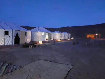 a group of tents in a desert at night at Dar chez ali in Mhamid