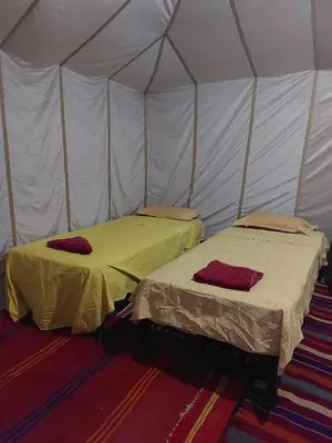 two beds in a tent in a room at Dar chez ali in Mhamid