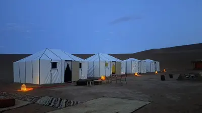 a row of tents in the desert at night at Dar chez ali in Mhamid
