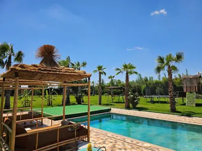 a resort with a swimming pool and palm trees at Maison D'hôte - Villa Privée et Paisible avec Déj' Marocain Offert