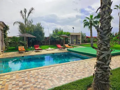a swimming pool with chairs and a palm tree in a yard at Maison D'hôte - Villa Privée et Paisible avec Déj' Marocain Offert