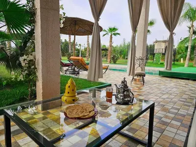 a glass table with a pizza on top of it at Maison D'hôte - Villa Privée et Paisible avec Déj' Marocain Offert
