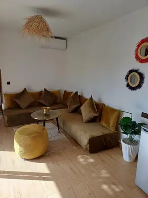 a living room with a brown couch and a table at Maison D'hôte - Villa Privée et Paisible avec Déj' Marocain Offert