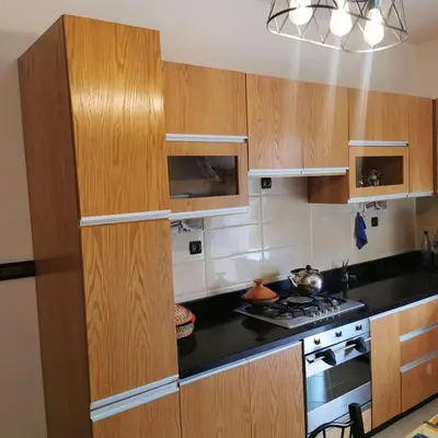 a kitchen with wooden cabinets and a stove top oven at dar hammouni