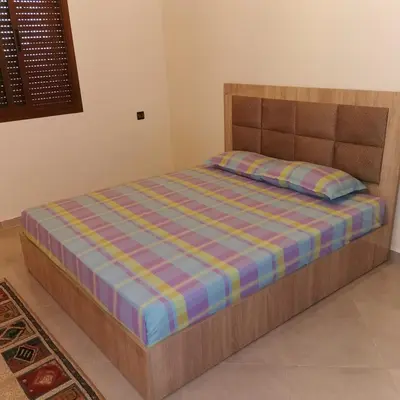 a bed with a wooden frame in a room at dar hammouni