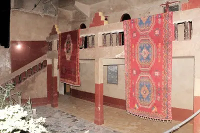 a room with three carpets hanging on the wall at Dar dmana chez l'habitant in Skoura