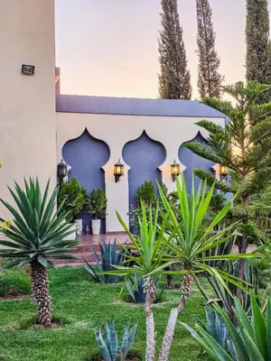a courtyard with palm trees and a building at Dar Muskana
